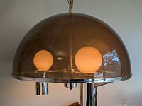 Angled view of pendant light showing smoked dome shade and internal glass globes