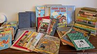 Wide view of the vintage children's books arranged on a table showing a variety of titles and wear condition.