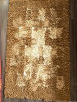 Full view of the vintage rya style rug showing the rectangular shape and brown to cream shaded abstract pattern.