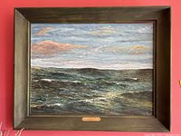 Front view of entire framed seascape painting showing ocean waves and sky
