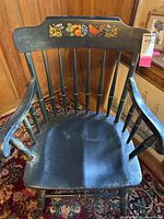 Top view showcasing the black wooden armchair seat with visible wear marks.