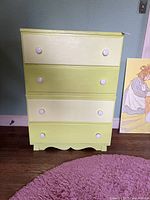 Front view of the Aristo Bilt painted wood dresser with alternating color drawers and white knobs, showing overall design and condition including scuffs and scratches.