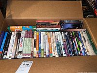 Box of DVDs showing front rows with titles including Pride and Prejudice, Zoolander, Mary Poppins, and exercise DVDs