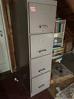 Front view of the 4-drawer metal file cabinet showing all drawers, handles, and label holders, with visible scratches and scuffs on the surface.