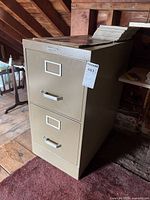 Side view of beige Statesman 2-drawer metal filing cabinet with handles and lock on top drawer.