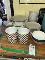 Overview of dishes including white ceramic plates and bowls, gingham bowls, and colorful Haniwa Stone bowls on table