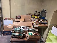 Overview of multiple open boxes and loose model train parts on table