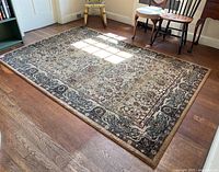 Full view of the rectangular Oriental Weavers of America rug on hardwood floor showing overall condition and pattern.