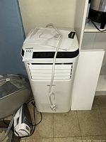 Front view showing unit's air vents, power cord and remote control placed on top.