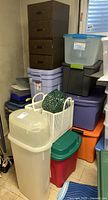 Overview of Rubbermaid storage bins stacked, showing different colors and sizes, including a tall translucent bin and plastic baskets.