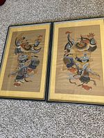 Two framed warrior paintings placed side by side on carpet