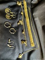 Photo showing all jewelry items laid out on black fabric including bracelets, earrings, and necklace.