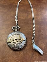 Photo of the gold and silver tone pocket watch with 'Grandpa' embossed on front and attached chain.