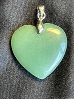 Full view of the smooth, polished green jade heart-shaped pendant with attached bail.
