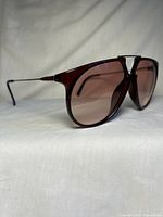 Three-quarter front view showing plastic frame and tapered tint rose lenses