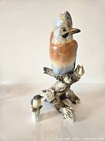 Large bird on branch base with smaller bird figurine alongside