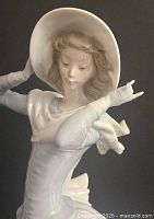 Close-up of the upper body and face of the figurine, showing detailed sculpture and hat.