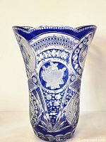 Full front view of cobalt blue cut-to-clear vase showing scalloped rim, clear rose medallion and geometric pattern detailing.