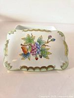 Top view of lid showing floral butterfly detailed design with gold trim.