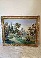 Full frontal view of the signed oil painting showing the landscape featuring a peacock and pond with gilt frame.