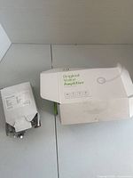 Closed boxes showing labels for book lamp and Original Voice Amplifier