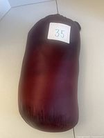 Sleeping bag rolled in burgundy stuff sack