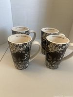 four floral mugs standing