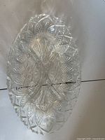 Top view of oval clear pressed glass platter showing geometric pattern and scalloped edge