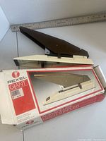 Stapler resting on original box, full view of both items