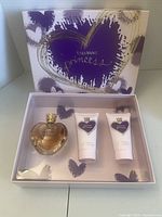 Open gift box showing perfume bottle and two body care tubes