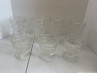 Seven clear cut glass goblets grouped together