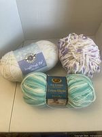 Three skeins of yarn showing labels and colours