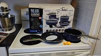Overview of the Blue Diamond cookware set on a stove including packaging boxes.