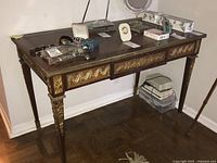 Full front view of desk showing three drawers, tapered fluted legs and ormolu decoration