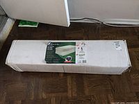 Photo of long closed box with product label and shipping details