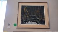 Front view of framed oil painting depicting birch trees and stream