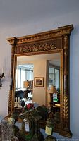 Full front view of gilded wood framed mirror on wall showing overall condition and design.
