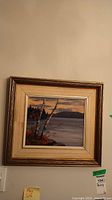 Full view of the framed oil painting depicting a lakeside autumn scene with tree and sky.