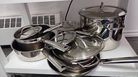 Stacked view of pots, pans, lids and steamer insert
