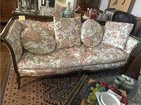 Three-quarter view of the wood frame sofa showing floral upholstery and four cushioned seats.