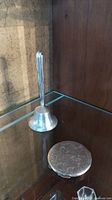 Photo showing the bell with sterling silver handle and the engraved sterling silver compact together.