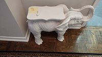 Full view of the white ceramic elephant shaped side table showing overall shape and condition