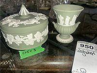 Photo showing Wedgwood trinket box with lid next to small vase, displayed on wooden surface with price tag.
