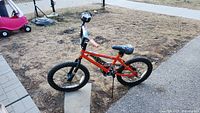 Side view of the orange Hot Wheels branded kids bike showing full bike, tires, and frame.