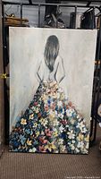 Front view of canvas painting depicting woman in a flower dress with her back to the viewer.