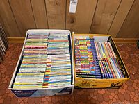 Two boxes filled with Archie comic books on a tiled floor against a wood-paneled wall.