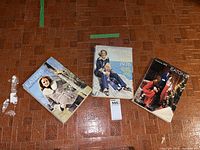 Three vintage Eaton's catalogues laid out on a tiled floor showing front cover designs