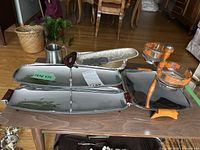 Overview of various serving platters and accessories on a table including a divided tray, hammered trays, and glass bowls with wood accents