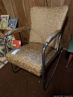 Front view of metal framed rocking chair showing padded vinyl upholstery and chrome frame