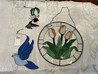 Three stained glass decorations on white cloth showing all items in lot.